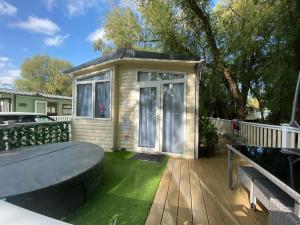 a tiny house with a bed on a deck at Luxury Holiday Home Happiness at Tattershall lake# in Tattershall