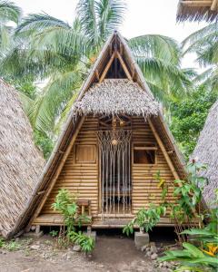 a small hut with a thatched roof at Mango Tree Eco-Hostel in Dauin