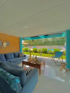 a living room with a blue couch and a table at Pousada Orquídeas do Guarujá in Guarujá