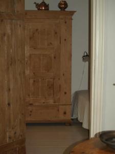 a wooden door in a room with a bed at Fadeburet på Skibstedgaard in Tvolm
