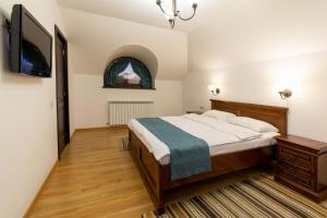 um quarto com uma cama e uma televisão de ecrã plano em Pensiunea Tara Fagilor em Suceava