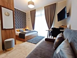 sypialnia z łóżkiem, kanapą i telewizorem w obiekcie Avangard by Baltic Home w Świnoujściu