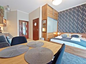 pokój z łóżkiem i stołem z krzesłami w obiekcie Avangard by Baltic Home w Świnoujściu +24 zdjęcia
