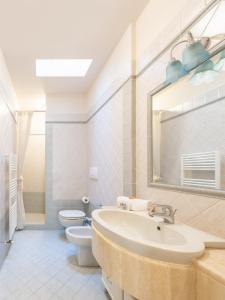 bagno con lavandino, servizi igienici e specchio di Elegante Villetta a Viareggio