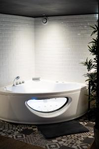 a white bath tub in a bathroom with white walls at Capsule Cinéma - Balneo home cinema playstation 5 in Valenciennes