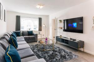 a living room with a couch and a flat screen tv at The White House - Grand & Spectacular 5-bed, sleeps 14- Central Solihull, NEC, JLR, HS2, Resorts World, Airport in Solihull