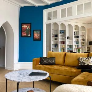 sala de estar con sofá amarillo y pared azul en Appartement hyper centre Perros-Guirec en Perros-Guirec