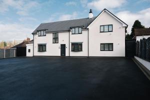 a white house with a large driveway at The White House - Grand & Spectacular 5-bed, sleeps 14- Central Solihull, NEC, JLR, HS2, Resorts World, Airport in Solihull