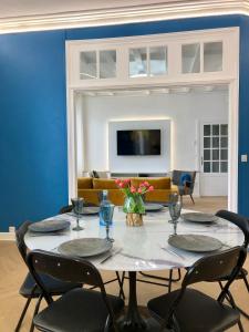 a dining room with a table with chairs and a couch at Appartement hyper centre Perros-Guirec in Perros-Guirec