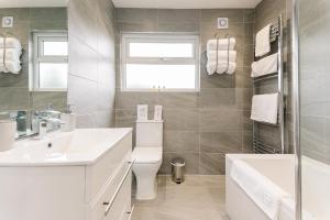 a bathroom with a sink and a toilet and a tub at The White House - Grand & Spectacular 5-bed, sleeps 14- Central Solihull, NEC, JLR, HS2, Resorts World, Airport in Solihull +72 photos