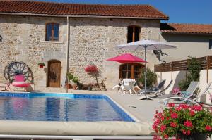 a house with a swimming pool and an umbrella at La Grange bnb in Yviers
