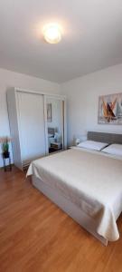 een witte slaapkamer met een groot wit bed. bij Apartments Donadic III, Caska in Novalja