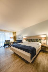 a bedroom with a large bed and a living room at Hotel Graf Bentinck in Dangast