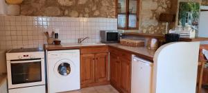 a kitchen with a washing machine and a sink at Gîte Les Fourches in Baudinard