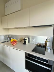 a kitchen with white cabinets and a stove top oven at Appartement vue mer à Gigaro, La Croix-Valmer in La Croix-Valmer
