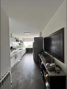 a kitchen with a large flat screen tv on the wall at Panoramic Sea View 2 Bedroom Apartment in Jbeil