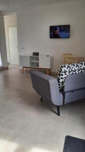 sala de estar con sofá y TV en la pared en Casa vacanze Titi', en Trapani