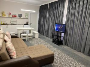 クサールにあるGuest houseのソファとテレビのあるリビングルーム