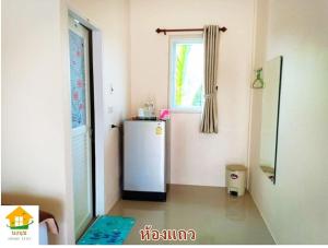 a kitchen with a refrigerator and a window at นงนุช โฮมสเตย์ & รีสอร์ท บุรีรัมย์ in Buriram