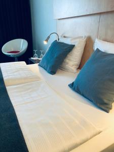 - un grand lit avec deux oreillers et une lampe dans l'établissement Good Morning + Bad Oldesloe, à Bad Oldesloe