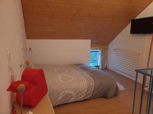 a bedroom with a bed in a room with a wooden ceiling at Ty Cœur in Bais