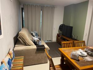ein Wohnzimmer mit einem Sofa und einem Tisch in der Unterkunft Condomínio novíssimo com total estrutura para vc in Arraial do Cabo