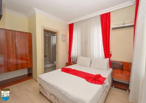 a bedroom with a bed with a red bow on it at BODENSEE HOTEL in Antalya