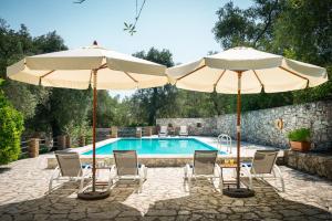 2 Sonnenschirme und Stühle sowie ein Pool in der Unterkunft Villa Eleni in Gaios