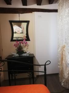 een slaapkamer met een bed en een tafel met bloemen erop bij Ca al Campanile in Venetië