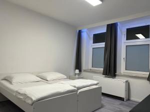 a bedroom with two beds and two windows at Freshly renovated City Apartments Essen near Düsseldorf Airport in Essen