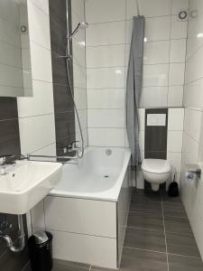 a bathroom with a sink and a tub and a toilet at Freshly renovated City Apartments Essen near Düsseldorf Airport in Essen