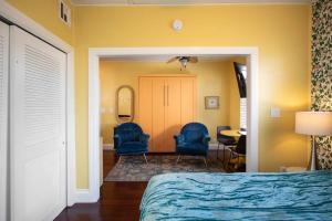 キーウェストにあるDuval Street Suite overlooking Duval with parking and poolのベッドルーム(青い椅子2脚、鏡付)