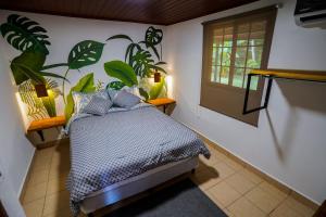 um quarto com uma cama com plantas na parede em Private Tropical Paradise - Gatuncrocs em Cuipo