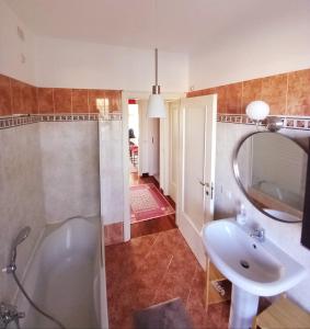 a bathroom with a tub and a sink and a mirror at Carachouse - Bologna in Bologna