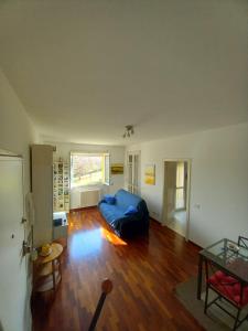 a living room with a blue couch on a wooden floor at Carachouse - Bologna in Bologna