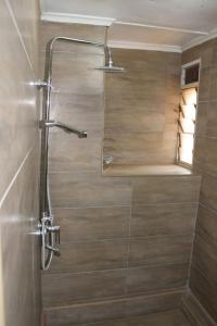 a shower with a glass door in a bathroom at Ibex Hill apartment in Lusaka