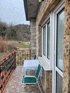 patio con mesa y sillas en el balcón en Guesthouse Petrović en Virpazar