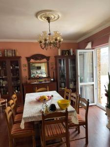 comedor con mesa, sillas y lámpara de araña en Guesthouse Petrović, en Virpazar