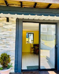 une porte en verre menant à une terrasse avec une table. dans l'établissement Atlantic Hostel Punta del Este, à Punta del Este