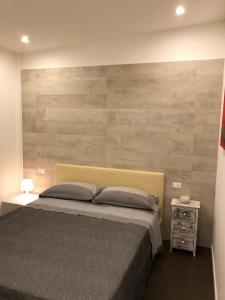 - une chambre avec un grand lit et un mur en bois dans l'établissement Exclusive Home 1, à Misano Adriatico
