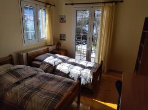 1 Schlafzimmer mit 2 Betten, einem Fenster und einer Tür in der Unterkunft Estel 2bedroom villa with fireplace in Grevena