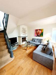 ein Wohnzimmer mit 2 Sofas und einer Treppe in der Unterkunft Villa Bon Accueil in Deauville