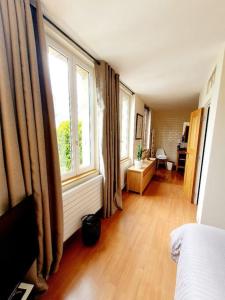 Zimmer mit einem Bett und einem großen Fenster in der Unterkunft Villa Bon Accueil in Deauville