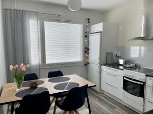 Polar apartment في روفانييمي: مطبخ مع طاولة وكراسي ومطبخ مع موقد