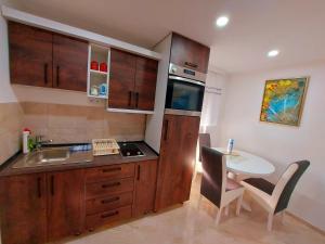 a kitchen with a sink and a table with a counter at Apartments Marshal in Bosanska Krupa