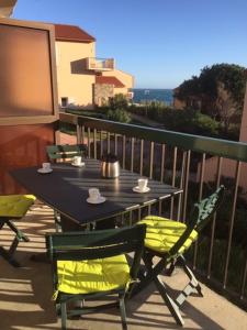 einen schwarzen Tisch und Stühle auf einem Balkon mit Meerblick in der Unterkunft Appartement Les Pieds dans l'eau in Collioure