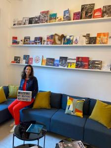 a woman sitting on a couch holding a sign at MY BOUTIQUE GUESTHOUSE - Fabulous Suites 10 Min A7 - in Anneyron