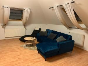 - un salon avec un canapé bleu et une table dans l'établissement Ferienwohnung Oelzschau - Urlaub im Leipziger Neuseenland, à Rötha