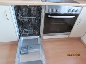 an open dishwasher in a kitchen next to a stove at Apartments bei Familie Liebl in Sankt Oswald +25 photos
