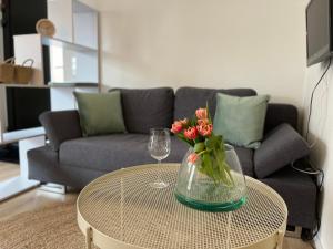 eine Glasvase mit Blumen auf einem Tisch im Wohnzimmer in der Unterkunft Moderne Ferienwohnung zum Wohlfühlen in Lindenberg im Allgäu